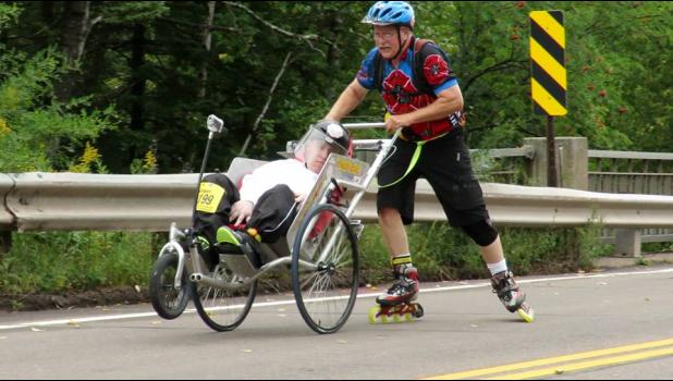 Darrell Knecht pushes son, Logan, in the racing chair he and Josh Smith built.